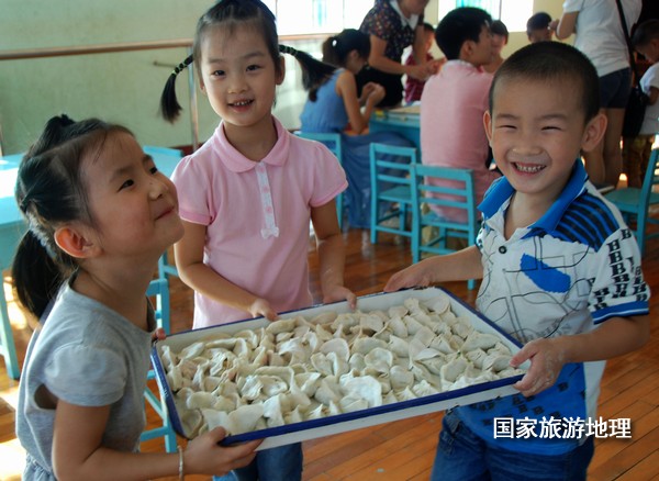 　　9月19日，三位孩子在搬运自己和亲人一起包的饺子，很是开心的样子。