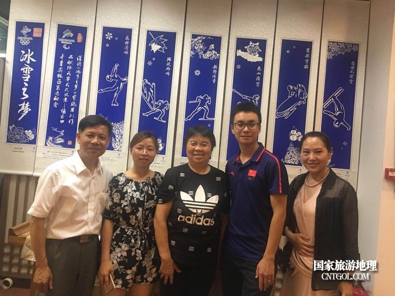 邓蓉蓉(中)与侯琨(右二)刘超英(左一)在剪纸展板前合影